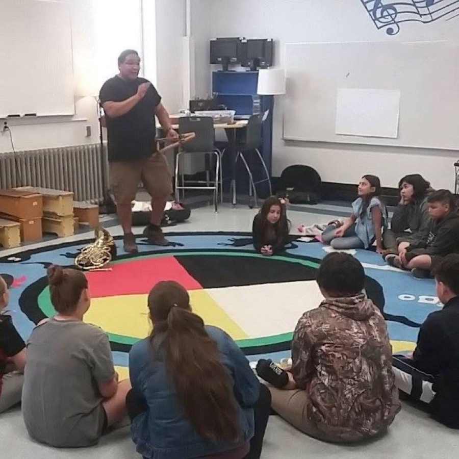 Walter leading a classroom workshop with students seated in a circle around a medicine wheel