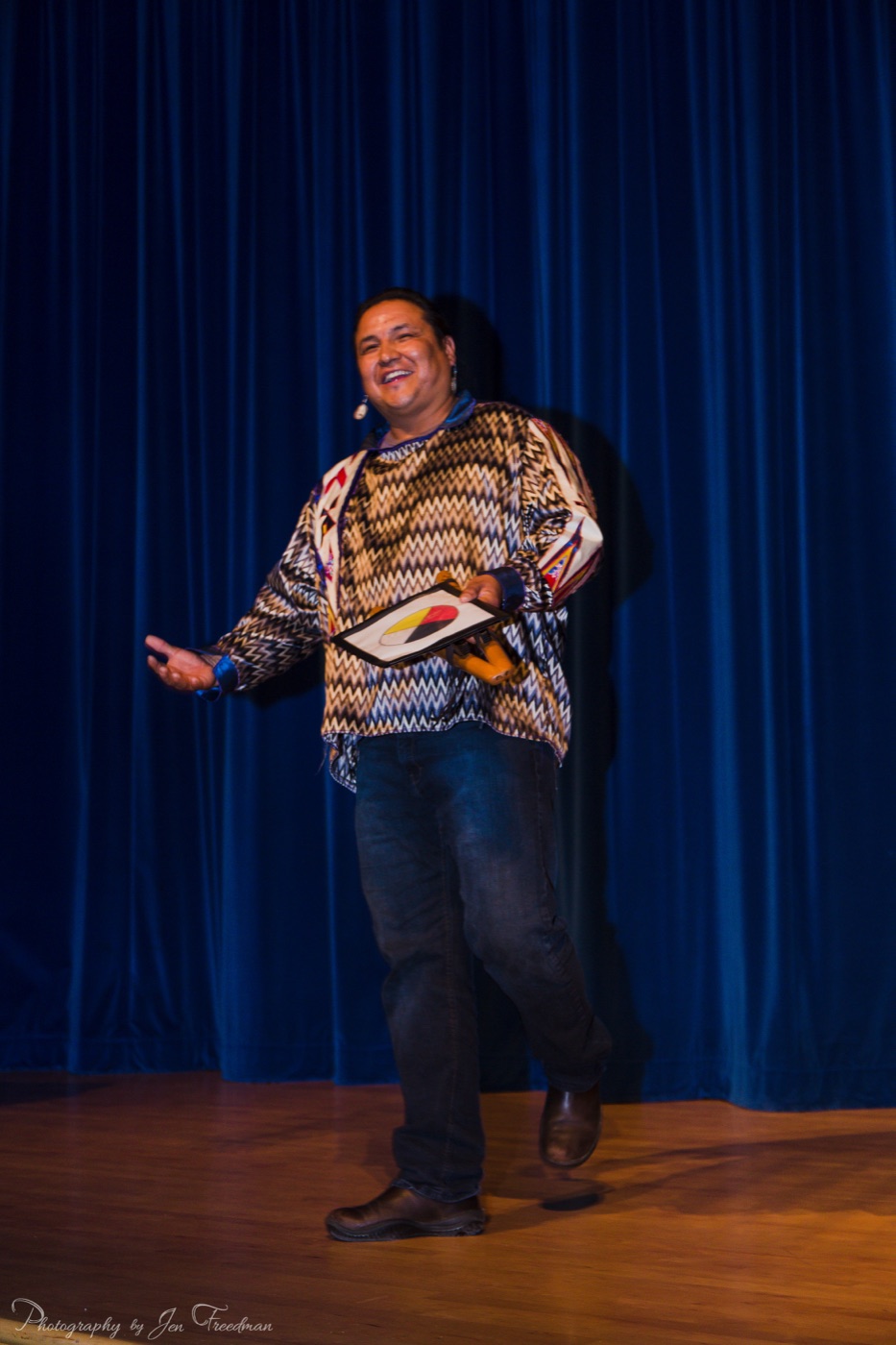 Walter performing on stage in front of a blue curtain